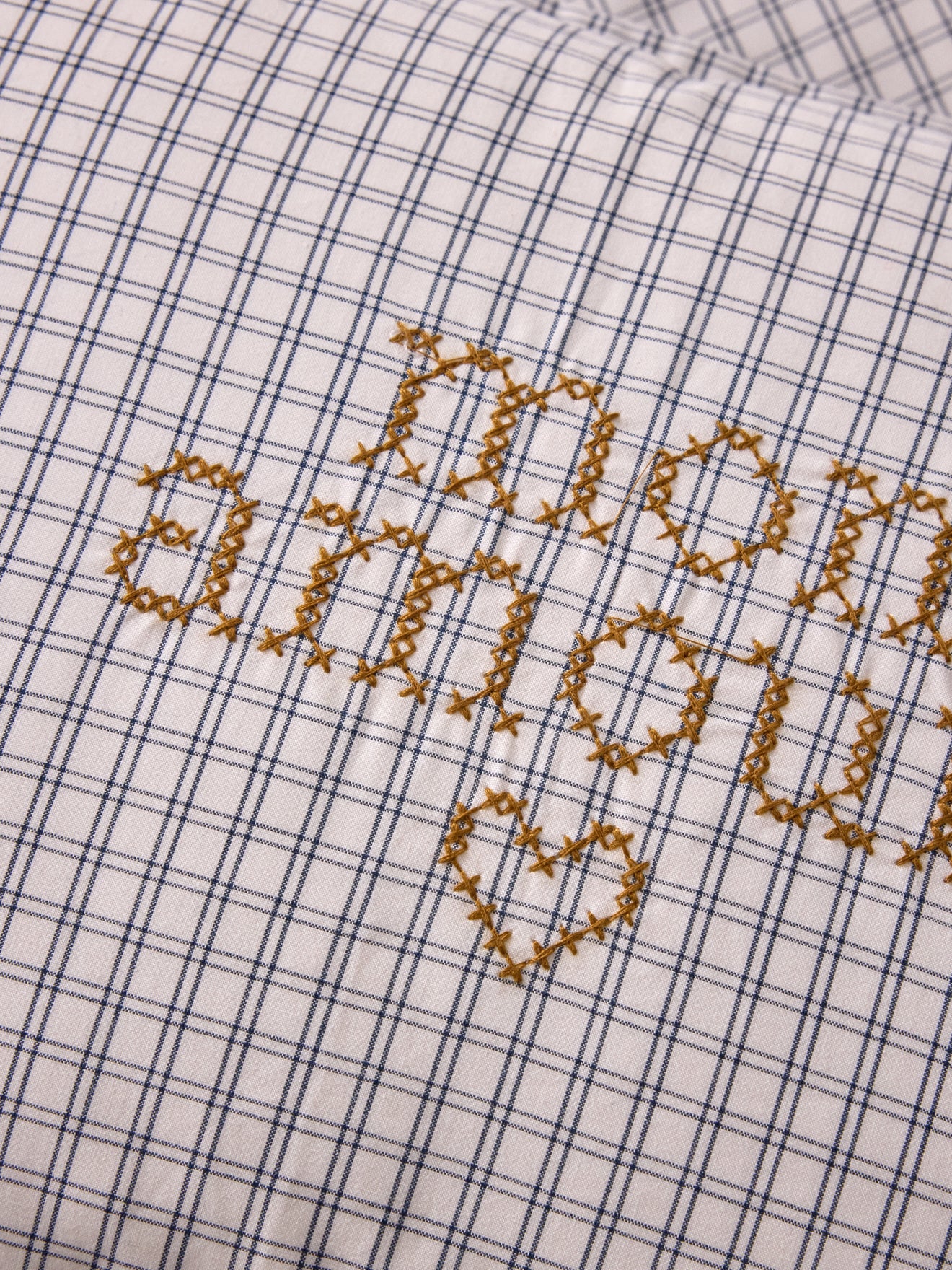 Housse de coussin petits carreaux brodée